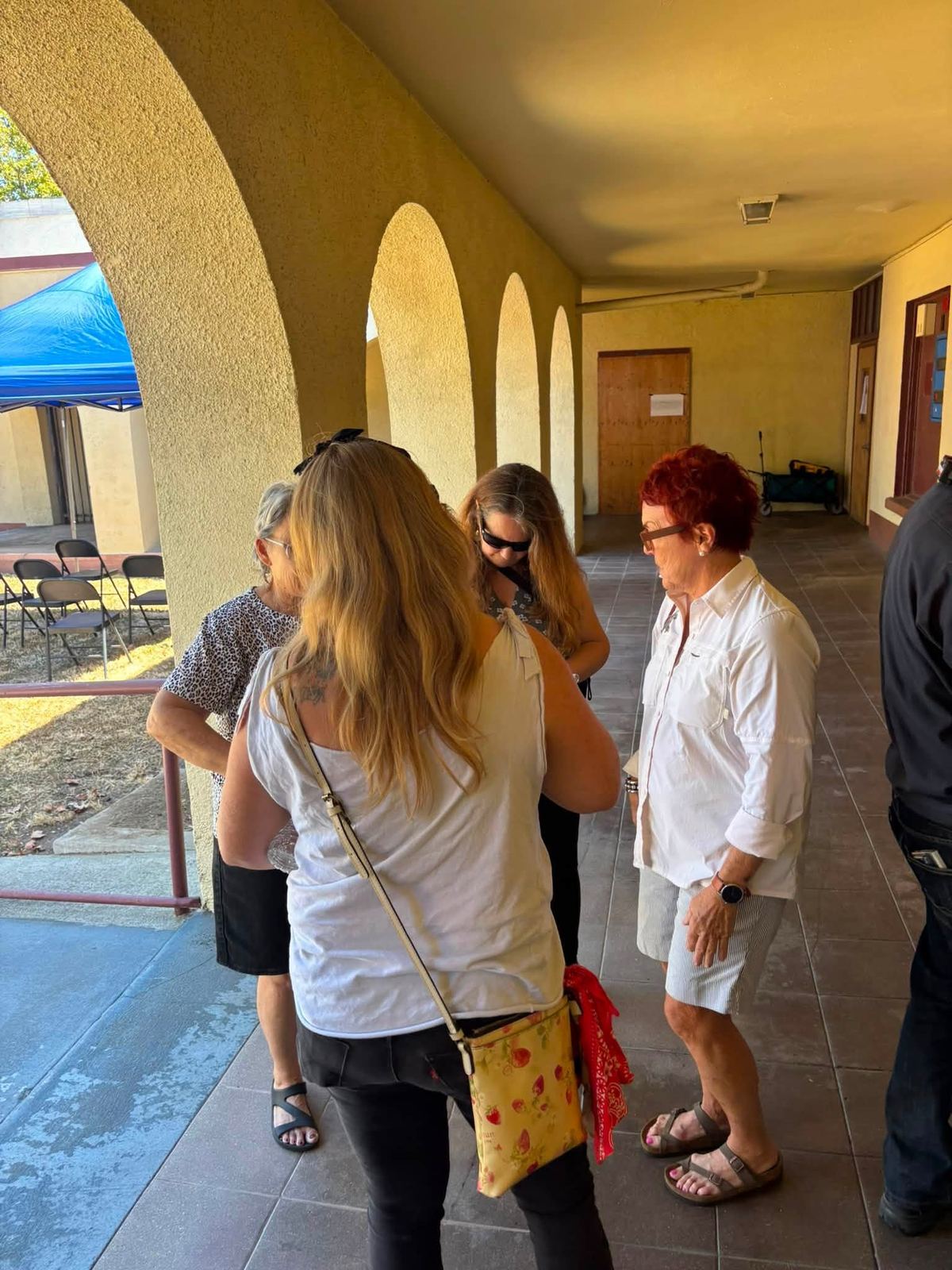 Neighbors talking under the school's arcade